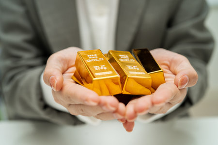 Asian woman holding gold bar in finance business.の写真素材