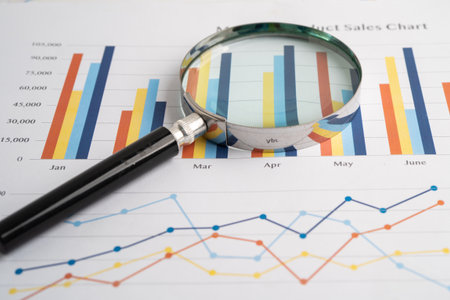 Magnifying glass on spreadsheet and graph paper. Financial development, Banking Account, Statistic,...