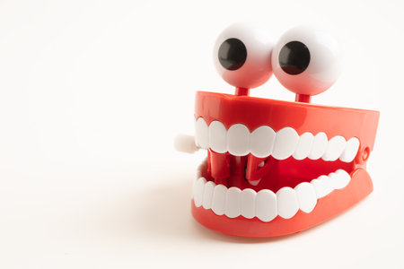 Tooth funny toy denture red color jaw and eye on white background with copy space.