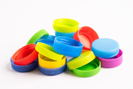 Plastic bottle colored screw caps for recycle waste on white background, container water lid.
