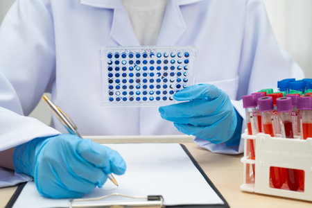 Scientist with cell culture in sample micro plate for research in science laboratory.
