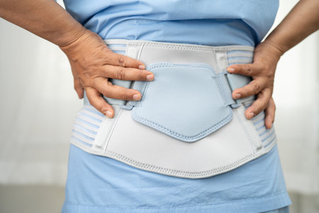 Asian lady patient wearing back pain support belt for orthopedic lumbar with walker.の写真素材