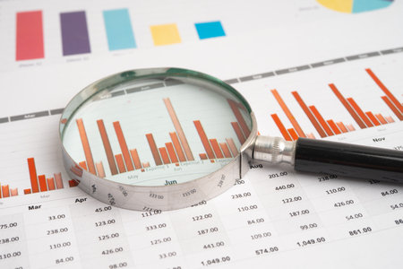 Magnifying glass on graph paper. Financial development, Banking Account, Statistics, Investment...