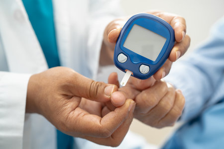 Doctor check diabetes from finger blood sugar level with finger lancet.の写真素材