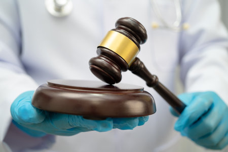 Doctor holding judge gavel, forensic medicine, medical law and crime justice.の写真素材