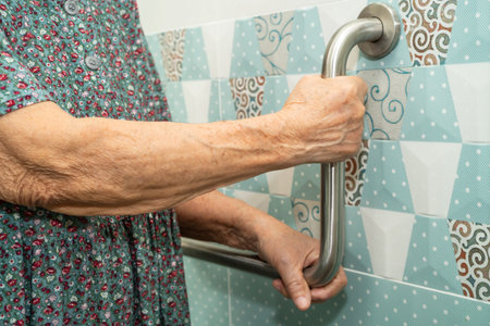 Asian elderly woman patient use toilet bathroom handle security in nursing hospital, healthy strong medical.の写真素材