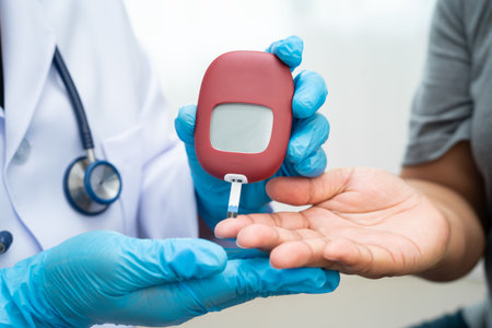 Doctor check diabetes from finger blood sugar level with finger lancet.