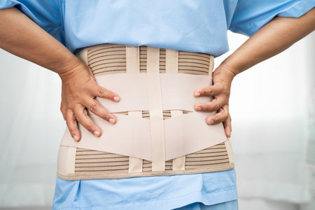Asian lady patient wearing back pain support belt for orthopedic lumbar with walker.の写真素材