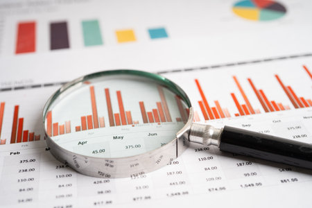 Magnifying glass on graph paper. Financial development, Banking Account, Statistics, Investment Analytic research data economy, Business concept.の写真素材