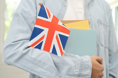 Learn English language, Asian teenage student hold book with flag in course at school.の写真素材