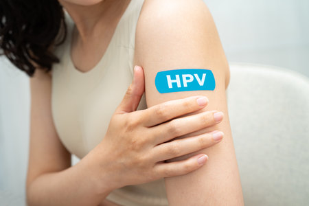 HPV, Human papillomavirus, Asian young woman receiving vaccine with blue bandage.