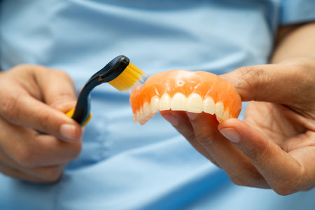 Asian senior woman patient clean teeth denture with toothbrush for chew food.の写真素材