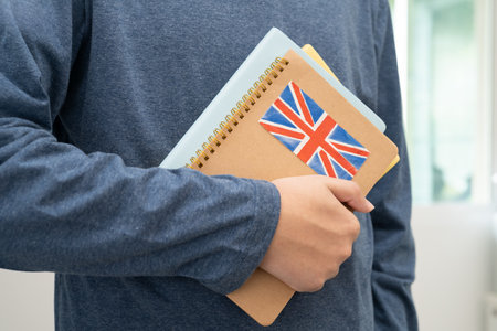Learn English language, Asian teenage student hold book with flag in course at school.の写真素材