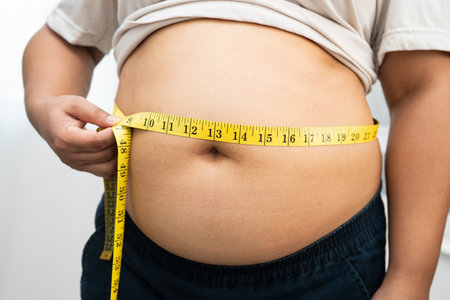 Asian woman with fat belly big size overweight and obesity with measure tape.の写真素材