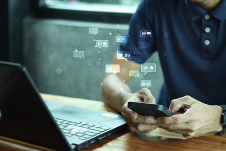 Social media concept.Young man social media on mobile phones with icons like notifications, Social media, and social network concepts.の写真素材