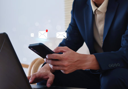 Email communication and digital marketing concept. Businessman receives email notification. business online communication, email communication, Receiving mobile phone and computer message alert.の写真素材