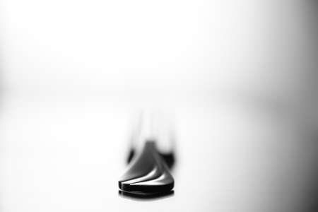 low key image of fork on glossy surfaceの写真素材