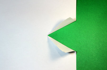 torn white paper triangle on green backgroundの写真素材