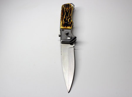 Knife with a black handle on a white background close-up