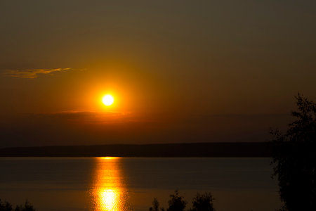 Sunset on the lake in the summer. The sun is reflected in the water.の写真素材