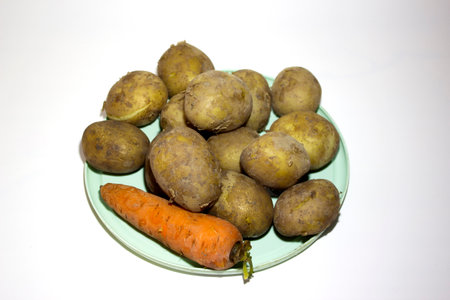 Boiled potatoes and carrots in a plate on a white background. Isolatedの写真素材