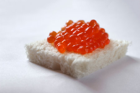 Red caviar on a slice of bread on a white background.の写真素材