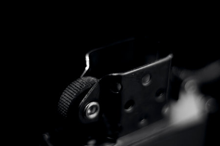 Detail of an old black and white cigarette lighter on black backgroundの写真素材