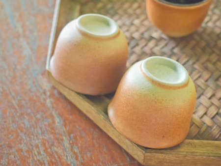 Overturn pottery cups on bamboo weaved saucer