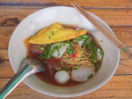 Thai style mixed noodle with ketchup on wood tableの写真素材