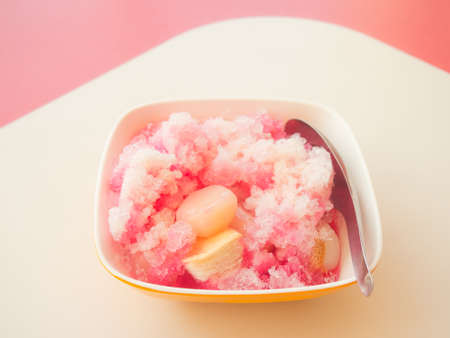 Bowl of crushing ice with strawberry syrup and sweeten milk and mixed garnish-Thai style dessertの写真素材