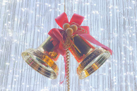 Ornamental silver bells with red ribbon on cristmas treeの写真素材