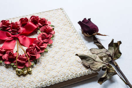 Close up of Love diary and Roses wilt on white canvas backgroundの写真素材