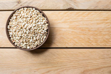 Millet seeds in can placed on a wooden backgroundの写真素材