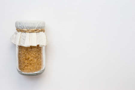 Sugar in glass jar on white canvasの写真素材