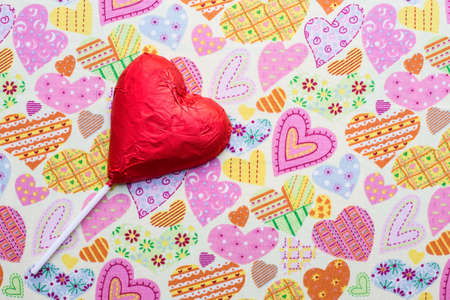 Close up of chocolate heart-shaped lollipop on fabric backgroundの写真素材