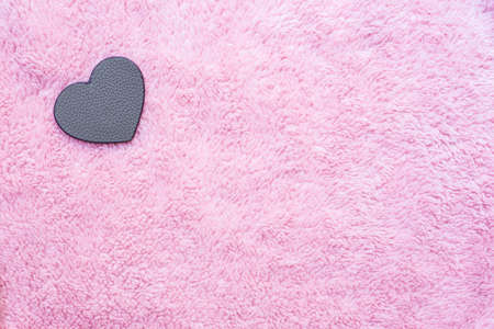 leather heart-shaped on pink artificial woolの写真素材