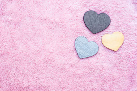 leather and wooden heart-shaped on pink artificial woolの写真素材