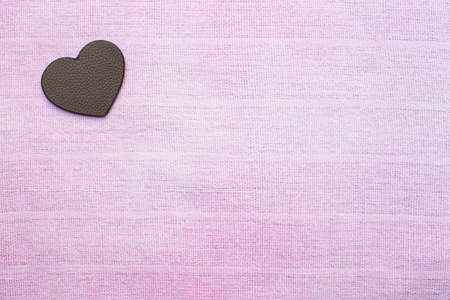 leather heart-shaped on pink fabric backgroundの写真素材