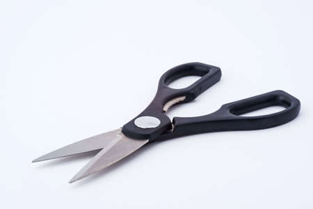 Scissors are hand-operated shearing instruments. They consist of a pair of metal blades pivoted so that the sharpened edges slide against each other when the handles (bows) opposite to the pivot are closed.の写真素材