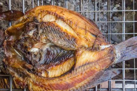 grill fish cooking on fire charcoal for delicious mealの写真素材
