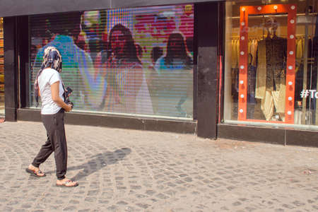 27th december 2020 kolkata west bengal india :A pedestrian walks past a multinational market in Kolkata's New Market area. Its elongated shadow is visible in the setting sun at noon.のeditorial素材