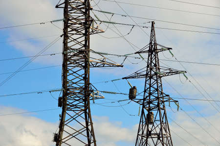 Electrical transmission pylons. High voltage. Blue sky with white clouds background.