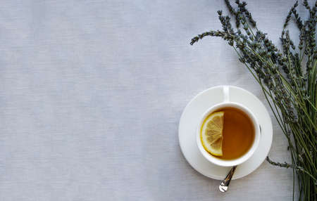 Banner Cup of tea with lemon and wild flowers. Grey background, mug and lavender.の写真素材