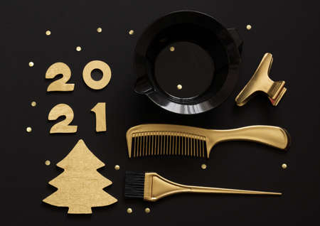 Accessories for hair coloring, numbers 2021 and a Golden Christmas tree. Black and gold color items, new year theme for hairdressersの写真素材