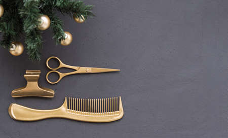 Banner with hairdressing tools in gold color and a Christmas tree on a dark gray background. Holiday template with hair salon accessories with space for text.の写真素材