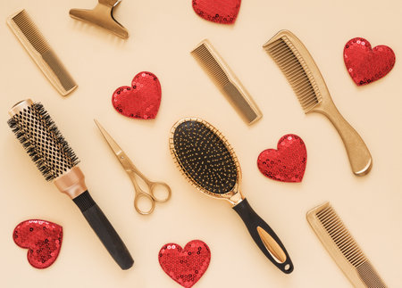 Valentines day background with hairdressing tools and hearts. Gold hair salon accessories.の写真素材