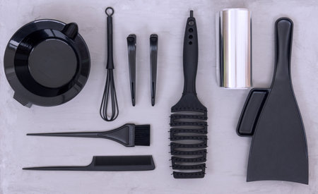 Hairdressing tools for hair dyeing. Hair salon accessories in black on a gray background.の写真素材