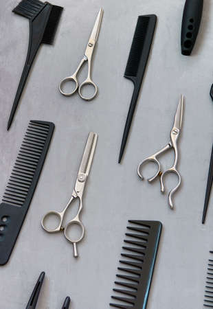 Full frame with hairdressing tools, combs, scissors on a gray background. Hair salon accessories, top view.の写真素材