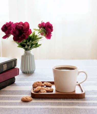 Still life with a cup of coffee and a book. The atmosphere of a cozy morning. Breakfast at home or in a cafe near the window.の写真素材