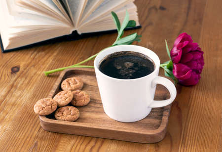 Still life with a cup of coffee and a book. The atmosphere of a cozy morning. Breakfast at home or in a cafe.の写真素材